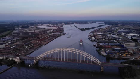 Puesta-De-Sol-Vista-Aérea-Del-Puente-Sobre-El-Norte-Con-Buques-De-Carga-Que-Pasan-Por-Los-Puertos-Interiores-Alblasserdam-Países-Bajos