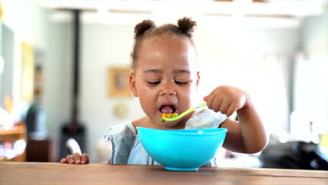 young south african girl eating her lunch with a blue bowl