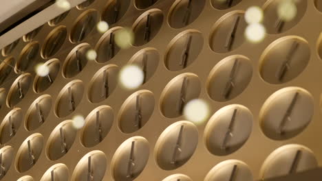 multiple simple clocks artwork with bokeh lights creating pattern hung in luxury watch store, slow panning shot