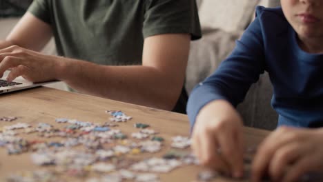 Video-of-boredom-boy-solving-jigsaw-puzzle-during-father-working