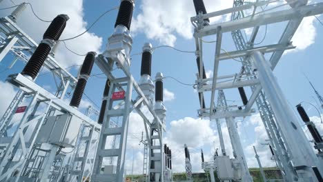 muchos aislantes eléctricos de alto voltaje en la subestación de energía contra un fondo de cielo azul