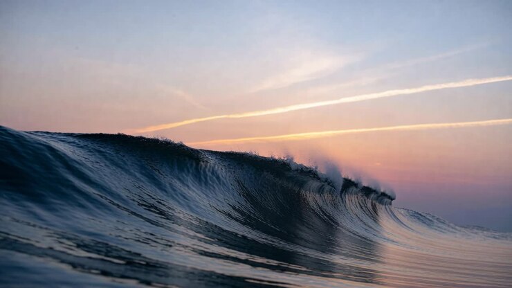 Vertical video: Surging ocean wave pushed by swell nearshore, curling, breaking into spray