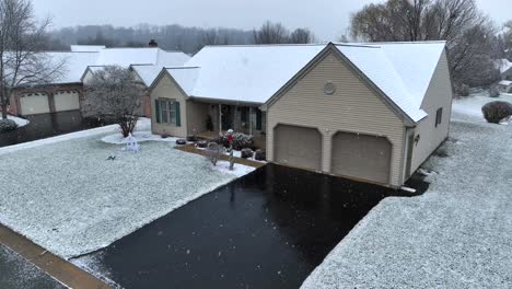 single-family home with beige siding under a light snowfall