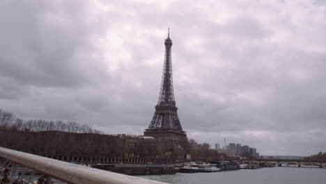 la torre eiffel en las orillas del río sena contra el cielo nublado en parís, francia