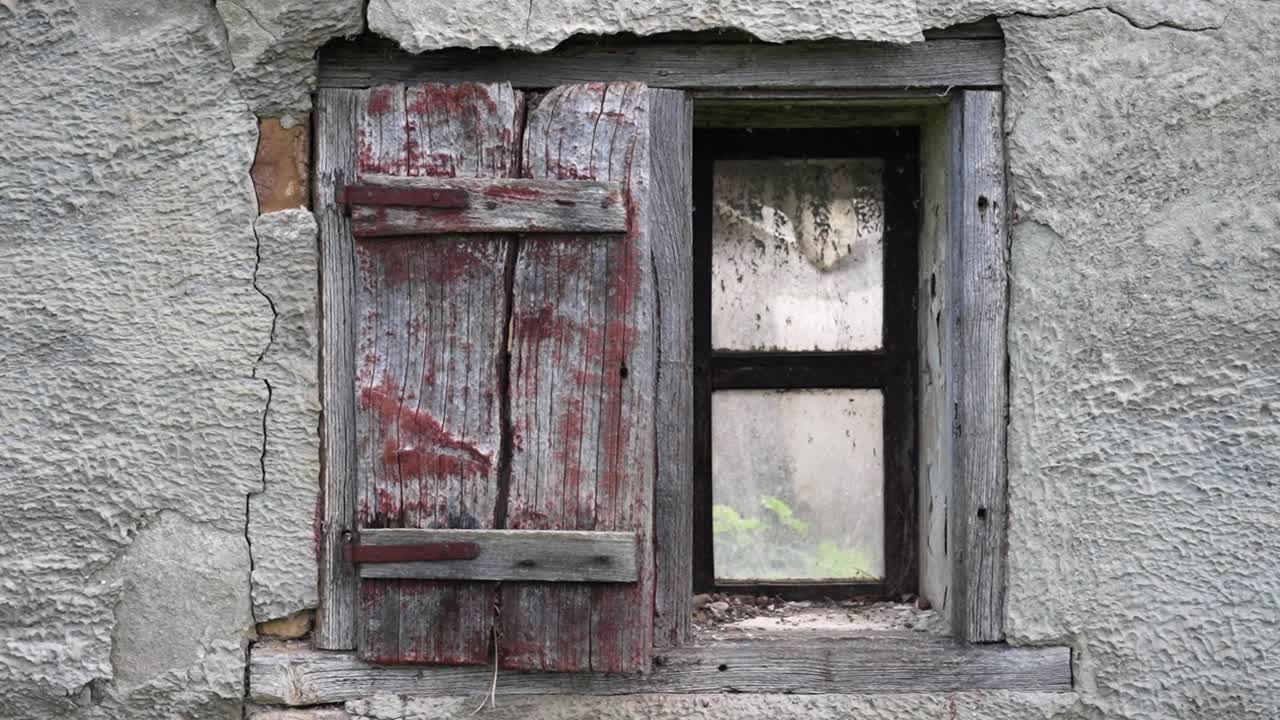 Close-up of an old wooden window shutter on cracked plaster wall