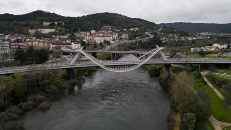 slow parallax around millennium bridge miño river in ourense, galicia, spain as cars drive over in fall