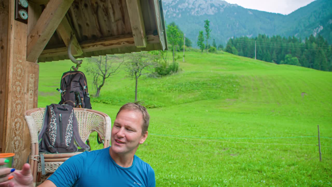 Couple drinking coffee outside their cabin. Having fun and smiling. Beautiful nature surrounding. Topla valley, Slovenia