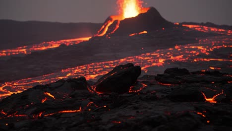 spectacular volcanic eruption displaying flowing lava illuminated by erupting ash and fire underneath the twilight sky in a breathtaking natural phenomenon