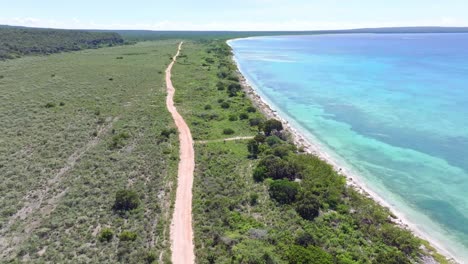 Aerial-shot-of-sandy-road-at-Las-Aguilas-beachside-in-Pedernales,-Dominican-Republic