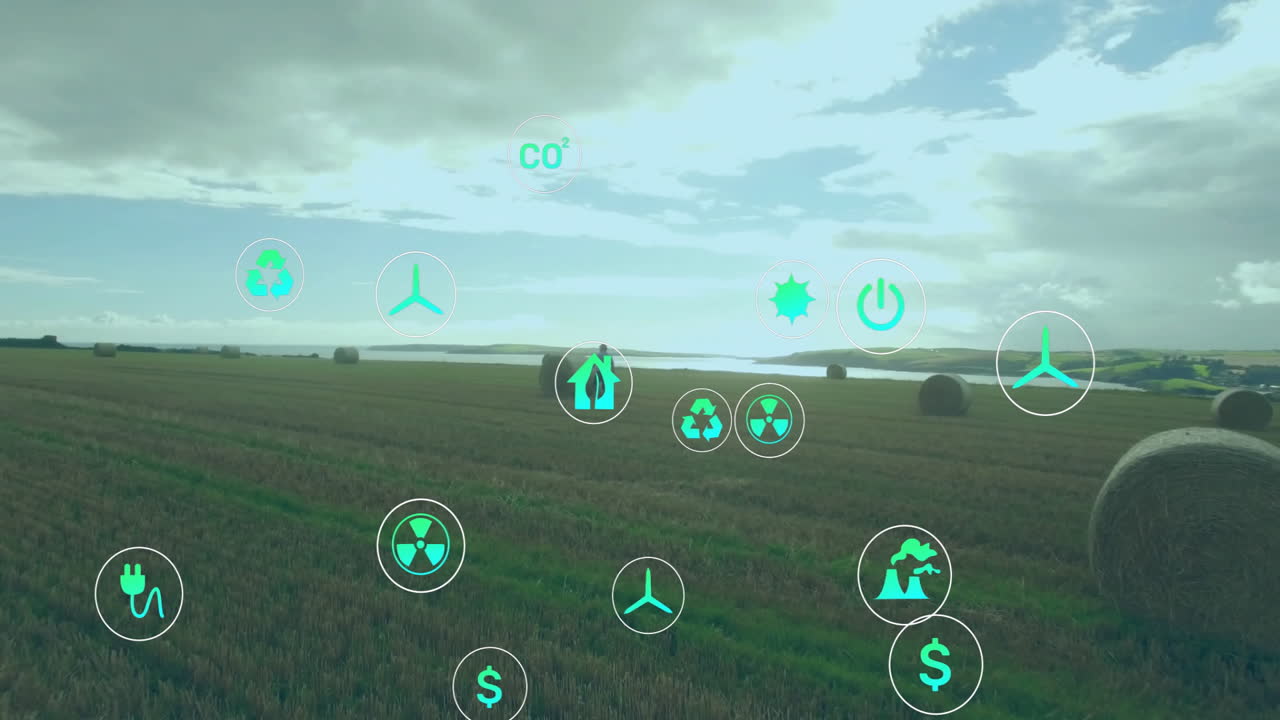 Harvested field showing floating wind turbine, recycling icons over hay bales for renewable energy