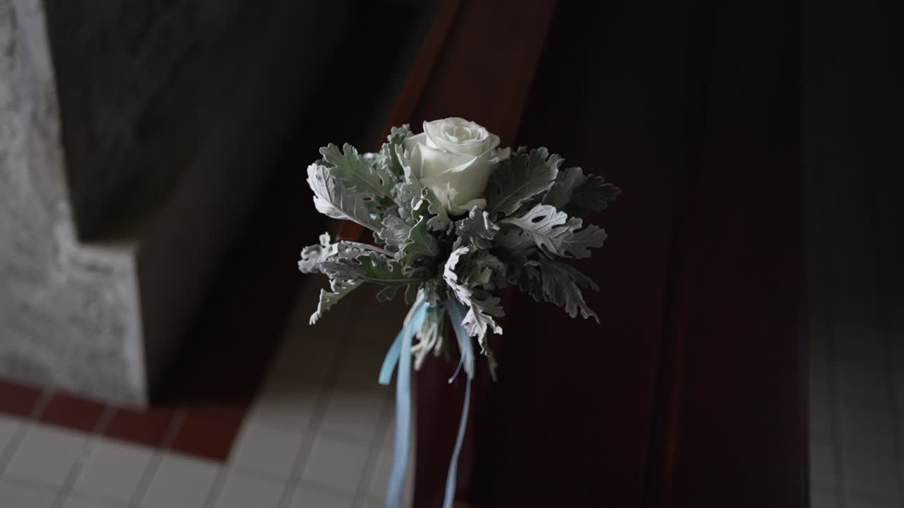 Elegant white rose with ribbon decor on wooden church pew
