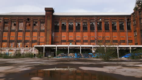 Exterior-De-Un-Edificio-Industrial-Abandonado,-Vista-Hacia-Adelante-Con-Plataforma-Rodante