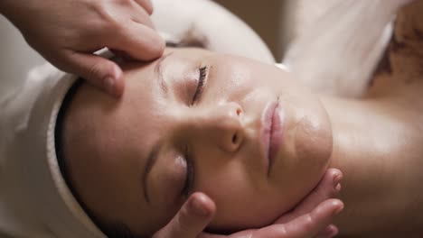 woman receiving facial massage at spa