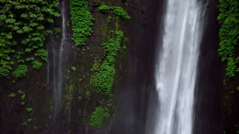 munduk falls is showcased in this serene scene, where cascading water flows amidst rich, lush tropical greenery. the natural setting epitomizes an idyllic tropical retreat.