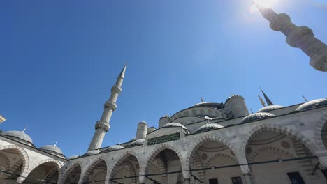 suleymaniye mosque establishing shot, vibrant blue sky above shines down on courtyard