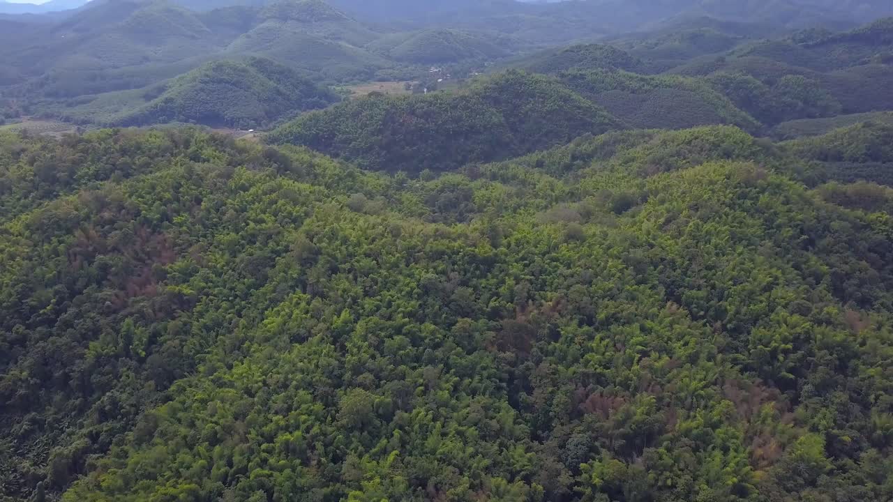 drones vuelan sobre exuberantes montañas verdes y valles bajo un cielo brillante durante el amanecer en tailandia