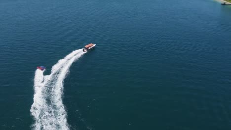 aerial tracks boat towing raft of happy tourists on bright sunny day