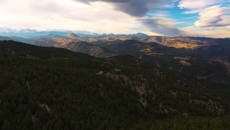 drone rises above pine tree forest to reveal incredible fall colored valleys from lost gulch overlook boulder colorado