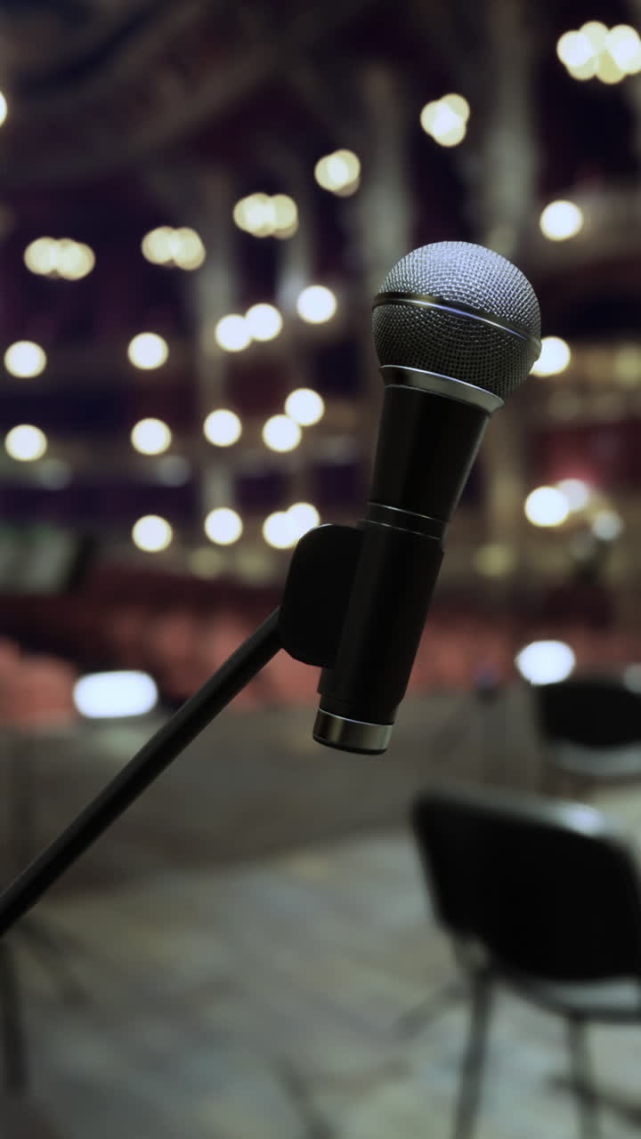 Un microfono pronto per l'esibizione in un teatro in una serata affollata.