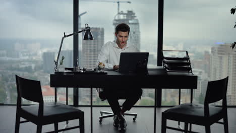 happy businessman reading good news on laptop screen