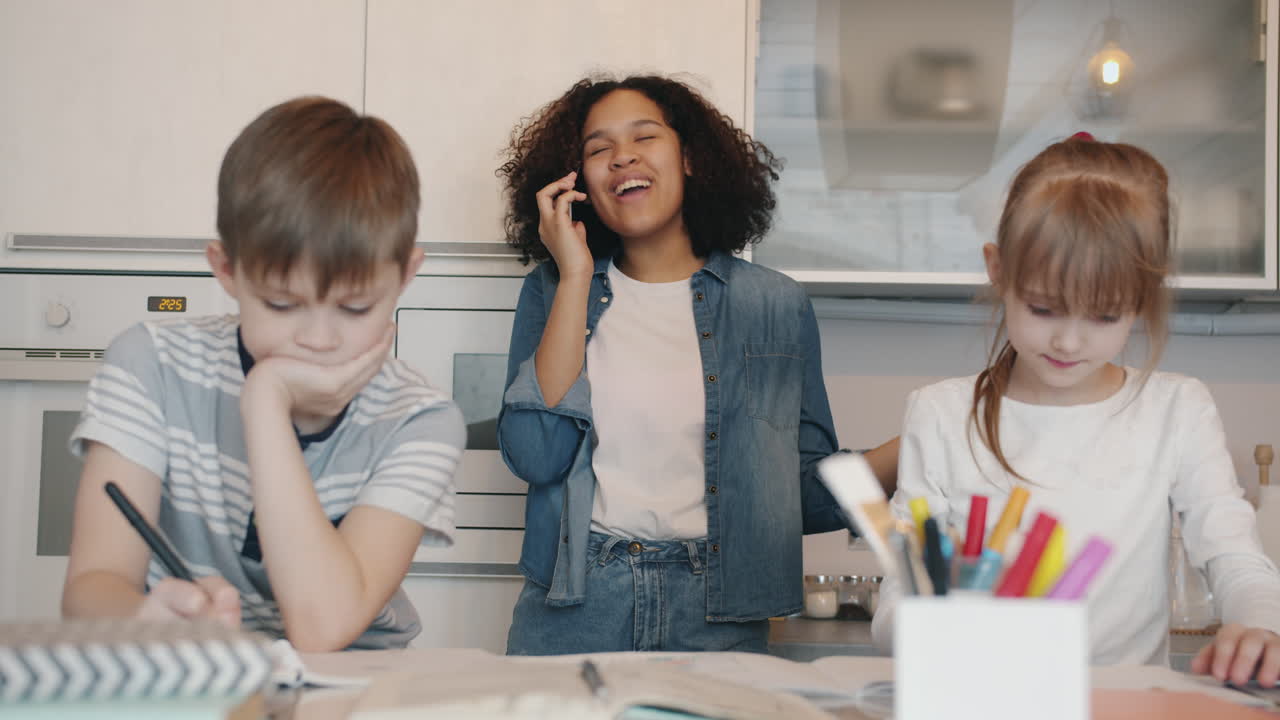 Bambini che fanno i compiti in cucina