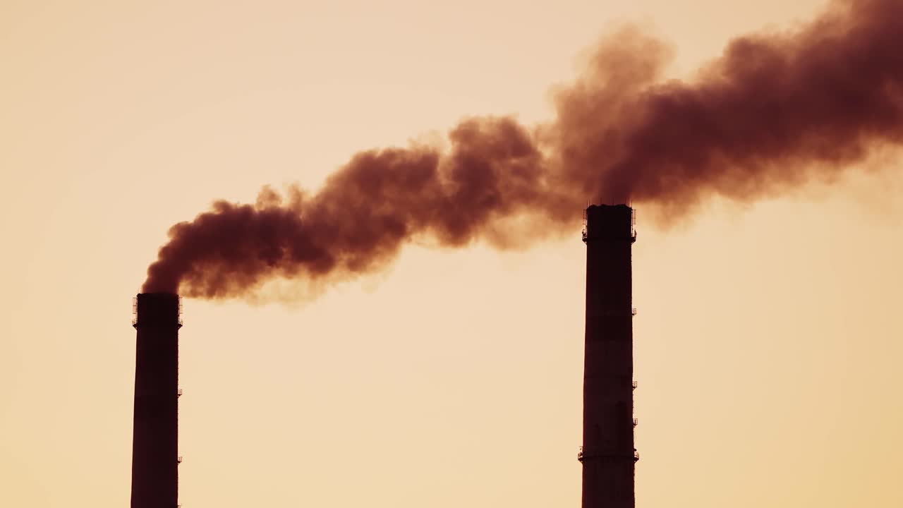 The steaming tube or pipe of the plant, factory or thermal power station on the background of dark sky. Monochrome video.