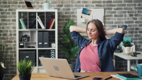 woman relaxing at her home office desk
