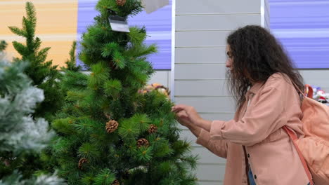 mujer comprando un árbol de navidad en una tienda minorista
