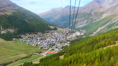 Green-summer-Saas-Fee-Saastal-gondola-tram-ride-down-to-ski-resort-town-Switzerland-fall-autumn-Swiss-Chalet-lark-forest-mountains-alps-valley-stunning-greenery-peaceful-sunny-mid-day-noon-cinematic