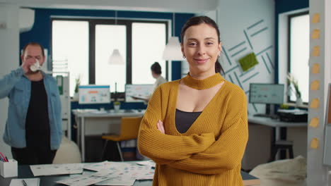 Portrait-of-confident-startup-employee-entering-frame-posing-with-arms-crossed-and-smiling