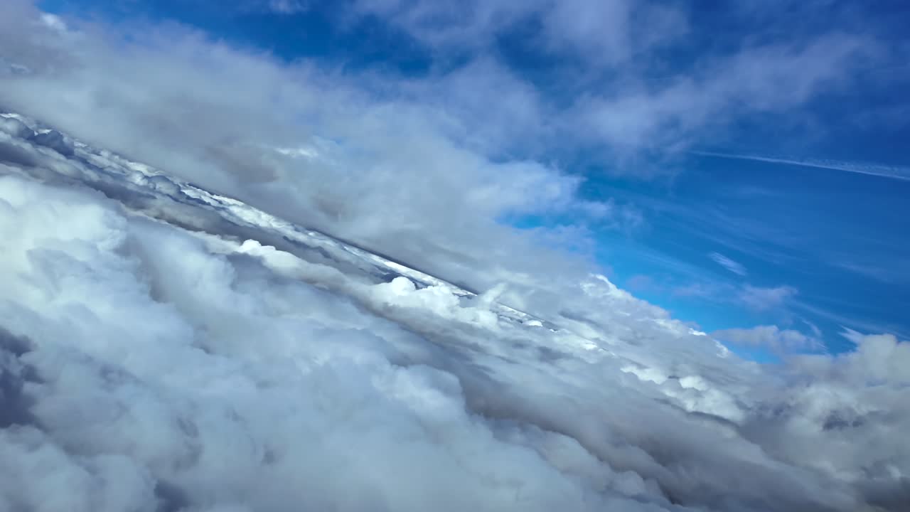 An immersive aerial cockpit footage flying through layers of ethereal stratus clouds under a deep blue sky, while doing a left turn