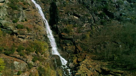 Corriente-De-Agua-En-Cascada-Por-Cadena-Montañosa,-Toma-Aérea-De-Naturaleza-Con-Drones