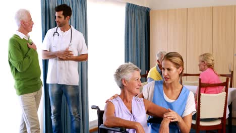 médico y enfermera interactuando con personas de la tercera edad