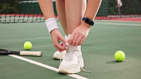 tying shoes on a tennis court