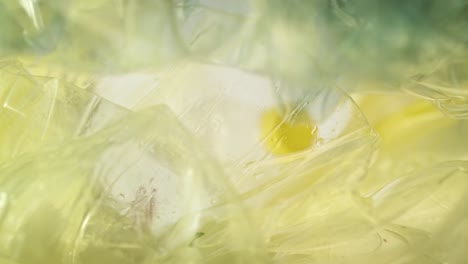 video of plastic bottles falling into a yellow garbage bag