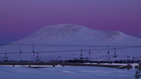 Ski-lift-in-Idre-Fjäll-in-Sweden-during-sunset-with-the-mountain-of-Städjan-behind-it