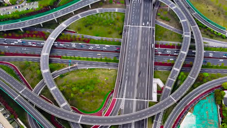 drone shot traffic on a large urban circular viaduct road interchange or highway intersection with busy urban traffic