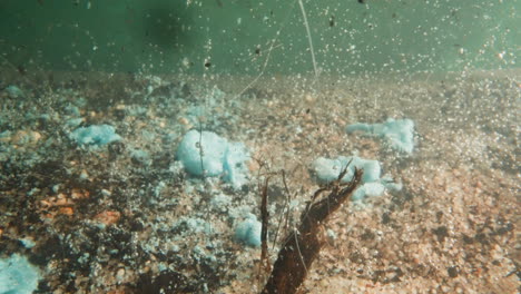 Industriematerialien-Fallen-In-Teichwasser-Mit-Kieselboden