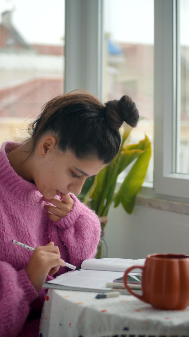 Giovane donna che studia e legge un libro a casa