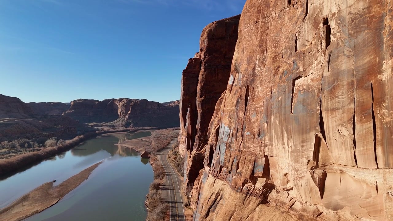 Toma de dron de acantilados escénicos sobre carretera y el río Colorado, paisaje cerca de Moab, Utah, EE. UU.