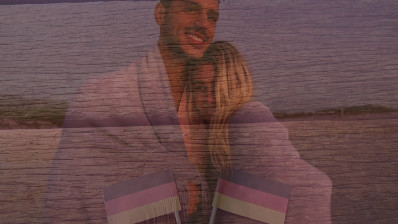 Embracing on beach, couple with flags overlay on wooden texture background