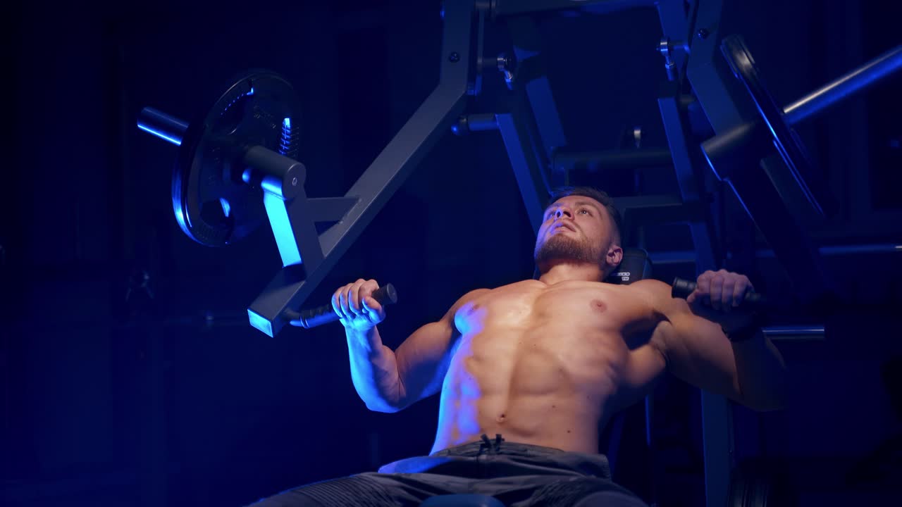 Fitness man in gym. Muscular man working out in gym doing exercises