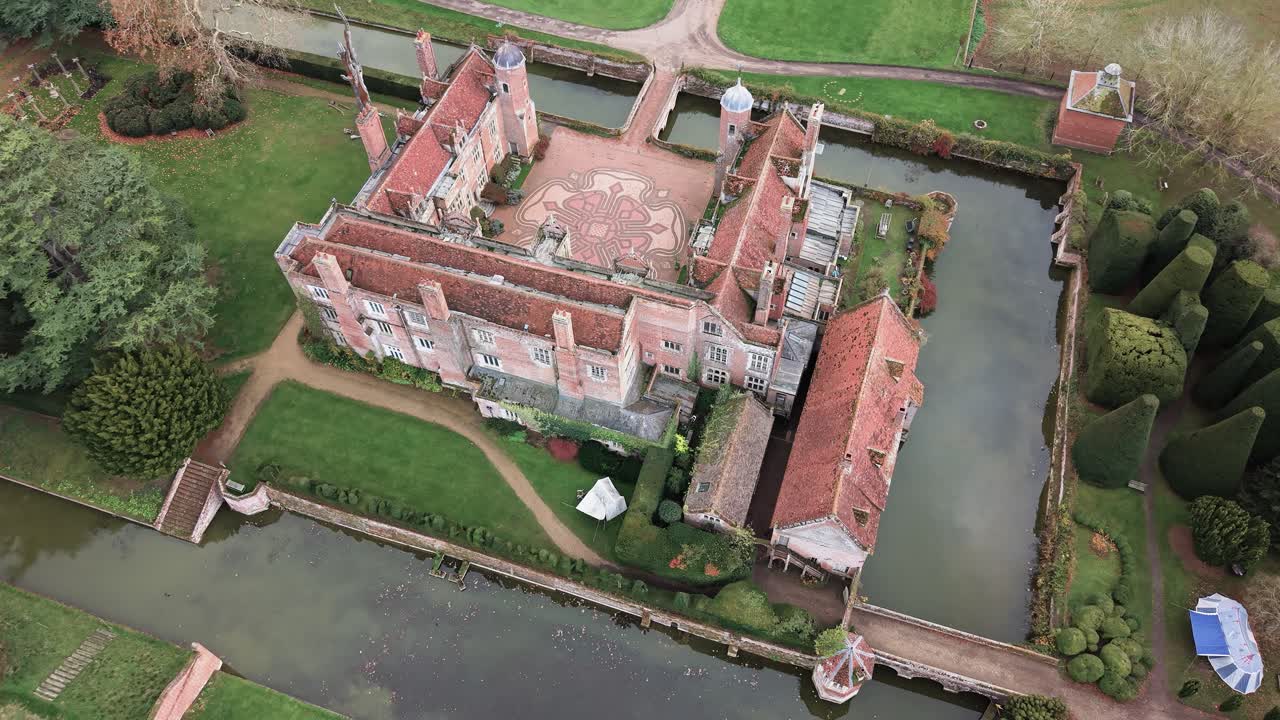 Kentwell Hall, Long Melford, Suffolk UK- Kentwell Hall Shows its Moated Layout, Red-Brick Tudor Architecture, and Intricate Patterned Courtyard Surrounded by Landscaped Gardens - Aerial Drone Shot