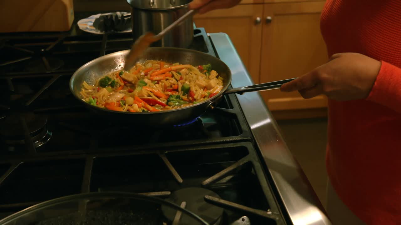 mujer cocinando comida en la cocina 4k