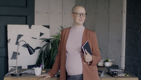 confident pregnant businesswoman in office