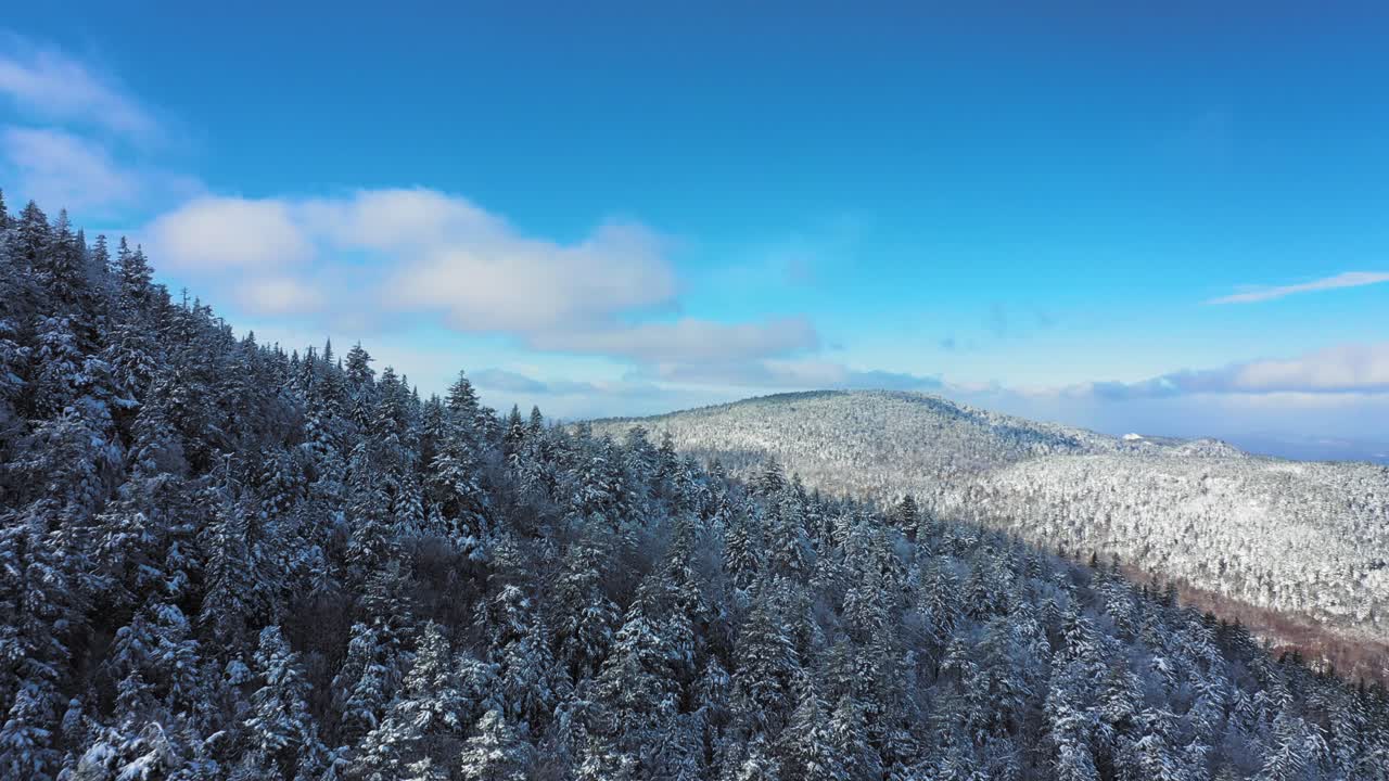 푸른 하늘 날 눈 덮인 산 능선 주위를 비행하는 항공 영상