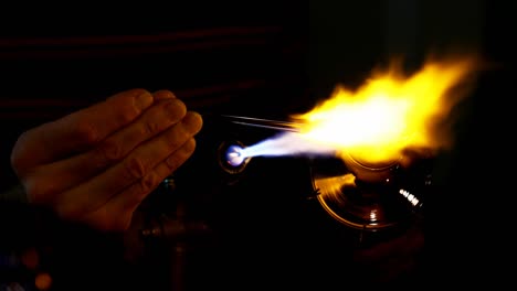 hombre de cerca trabajando con soplador de vidrio antorcha llama
