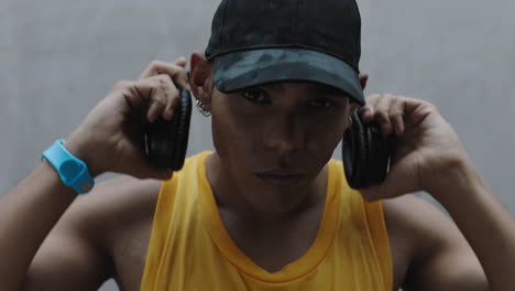 Retrato-Joven-Hombre-De-Raza-Mixta-Escuchando-Música-Se-Quita-Los-Auriculares-Sonriendo-Feliz-Mirando-La-Cámara-Disfrutando-De-Un-Estilo-De-Vida-Despreocupado-De-Cerca