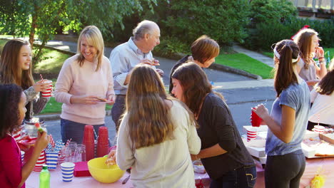 Neighbours-stand-talking-and-eating-at-a-block-party