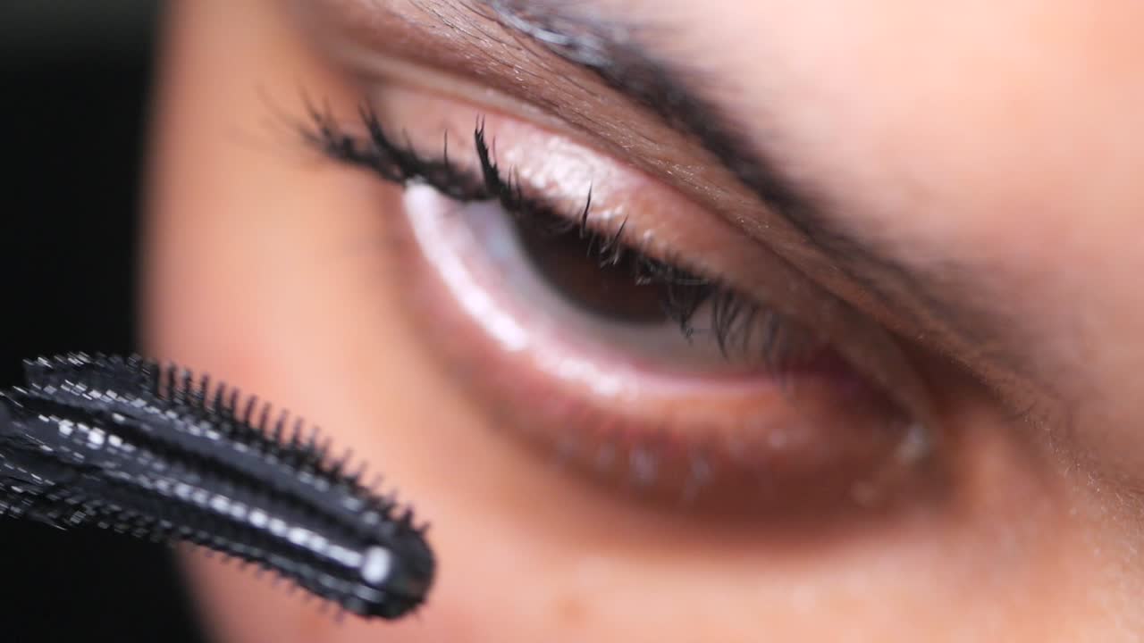 Close-up of a person applying mascara to their eyelashes